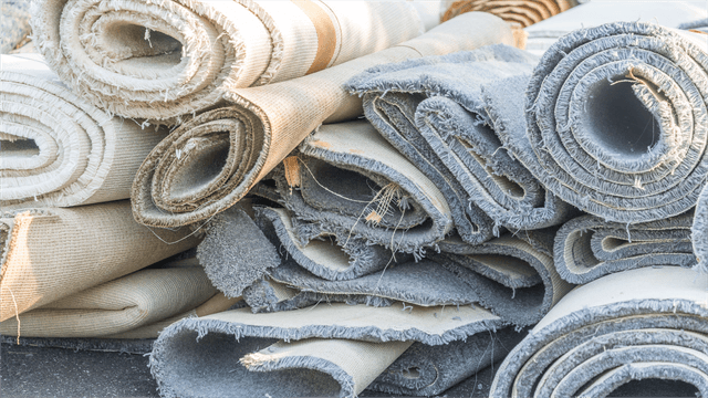 Rolled old carpets stacked together ready for recycling or disposal